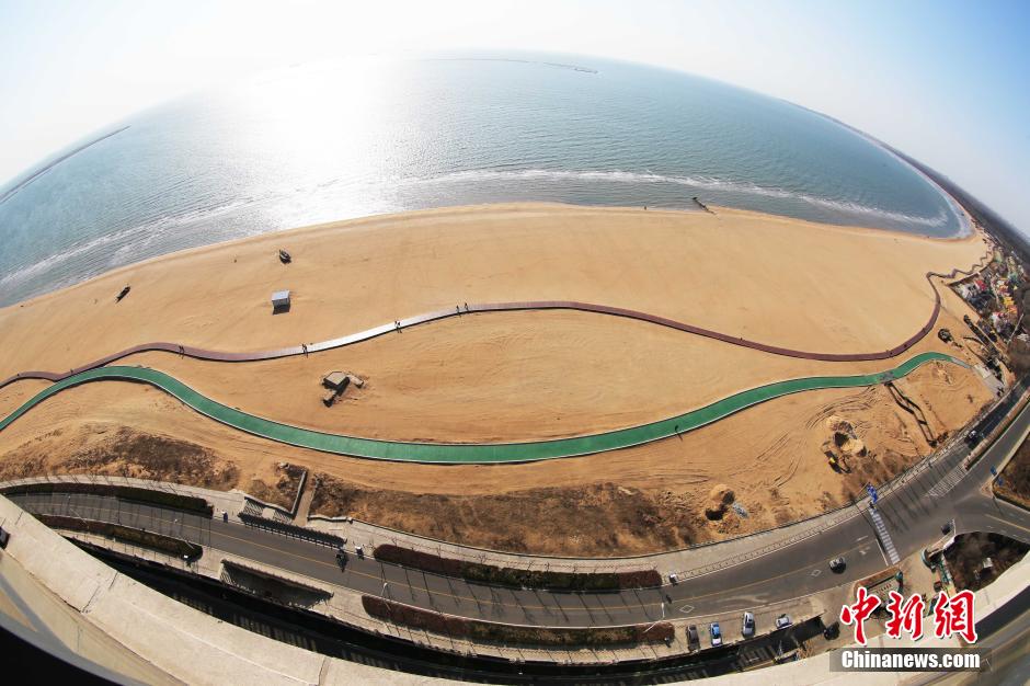 3月13日，秦皇島萬米臨海沙灘木棧道。據(jù)了解，該木棧道全長約4200米，與北戴河區(qū)原有的7500米木棧道對接后全線總長度1.17萬米，整個木棧道東起秦皇島體育基地游船碼頭，西至北戴河濕地公園，呈波浪形蜿蜒10.4公里海岸線。 中新社發(fā) 曹建雄 攝 CNSPHOTO